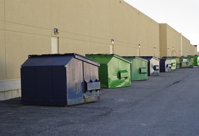 tilted front-load dumpsters being emptied by waste management workers in Cambria, CA